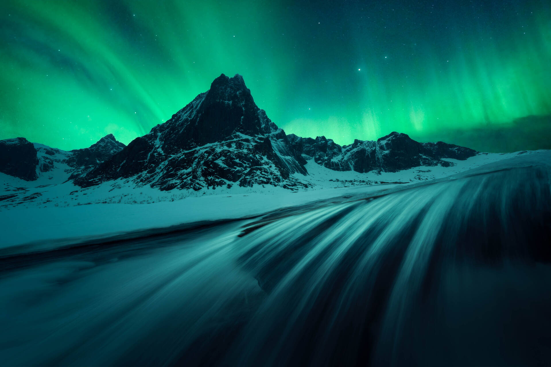 Bright green Aurora covering the entire night sky over a mountain