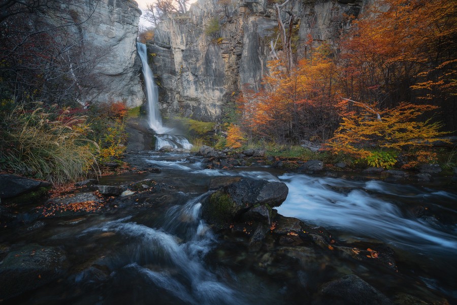 Waterfall surrounded by trees with bright fall colors
