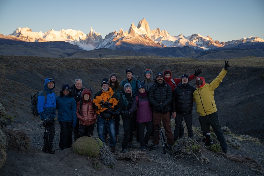 A group of people posing in front of the Fitz Roy and Cerro Torre mountains in Patagonia