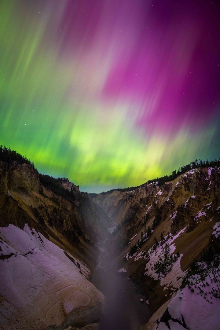 Northern Lights in Yellowstone Northern lights fill the sky over a canyon in Yellowstone