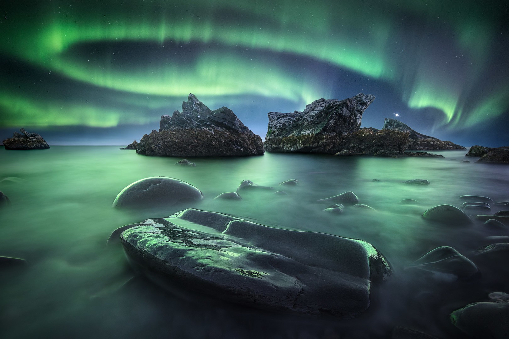 Aurora covering the entire night sky in Russia Strong aurora pilars cover the sky over rocks and the sea